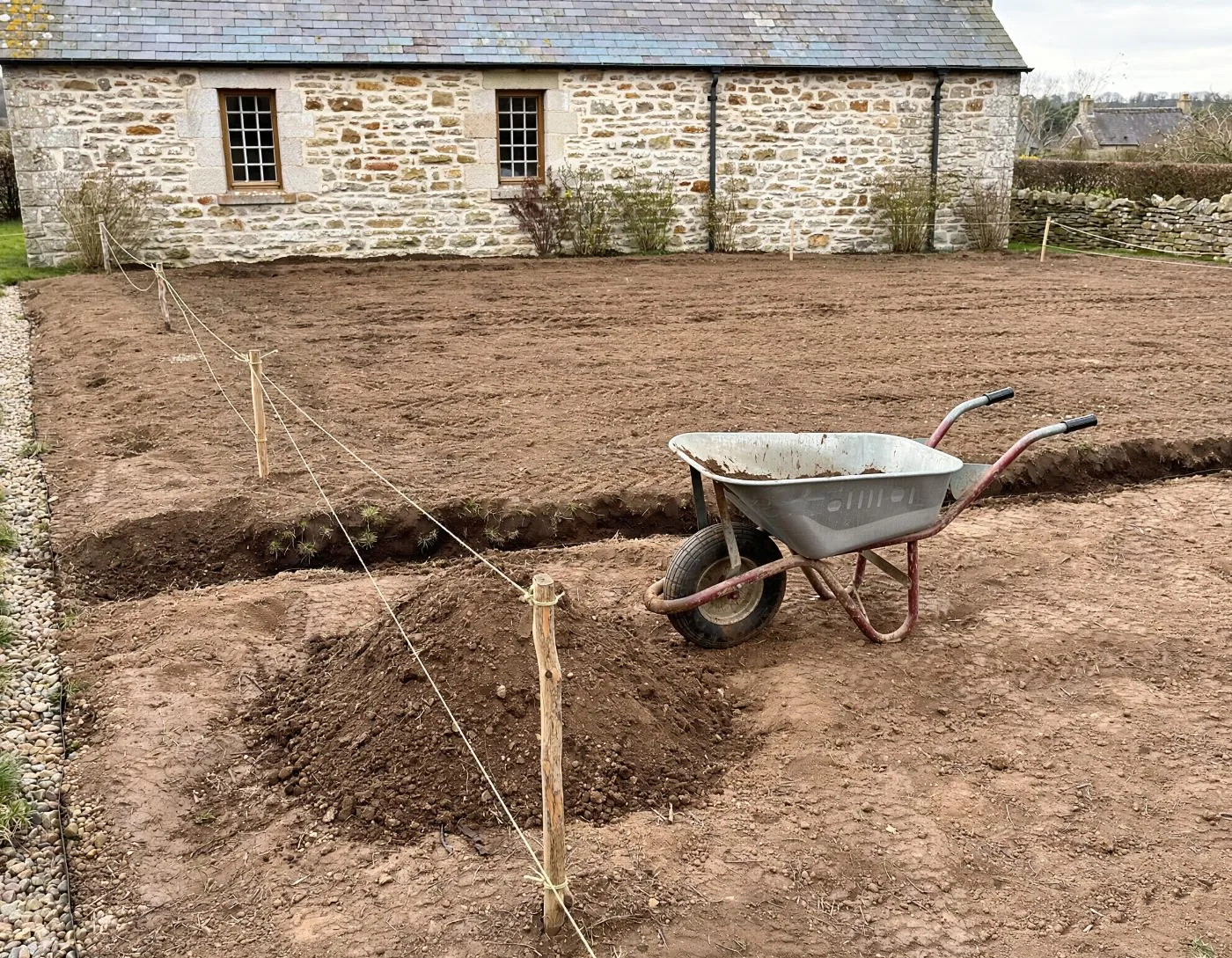 Terrain nu, terre retournée derrière la maison